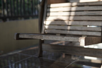 Close-up of a wooden bench with sunlight and shadows.