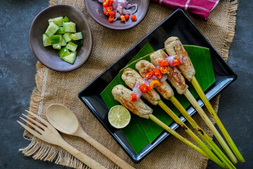Sate lilit or satay lilit food from Bali, Indonesia. Sate can be made from fish, or chicken, beef, mixed with grated coconut, thick coconut milk wrapped around lemongrass stalks