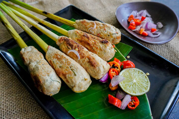 Sate lilit or satay lilit food from Bali, Indonesia. Sate can be made from fish, or chicken, beef, mixed with grated coconut, thick coconut milk wrapped around lemongrass stalks