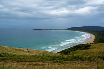 Scenic Coastal View with Gentle Waves and Green Hills
