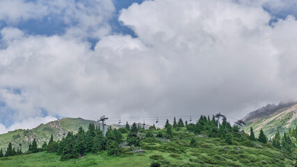 Chairlift Over Alpine Green Hills with Cloudy Sky