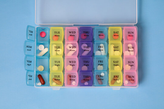 Weekly pill organizer filled with colorful medicine for each day and time