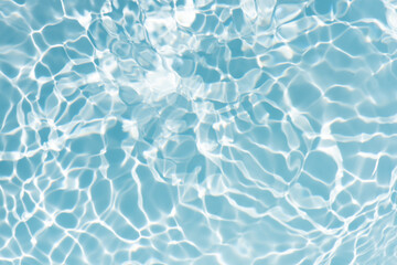 Blue water with ripples on the surface. Defocus blurred transparent blue colored clear calm water surface texture with splashes and bubbles. Water waves with shining pattern texture background.