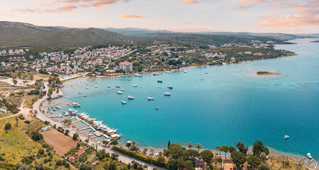 Aerial view of picturesque coastal town, with boats dotting the turquoise sea under a vibrant...