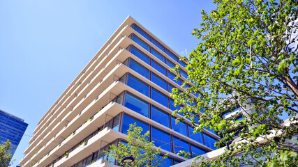 Office with green environment. Corporate building reduce CO2. Sustainable glass office building with trees for reducing carbon dioxide. Eco-friendly building in modern city.