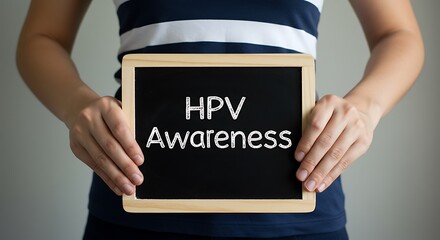Person Holding Chalkboard with HPV Awareness Message on Neutral Background for Health Campaigns