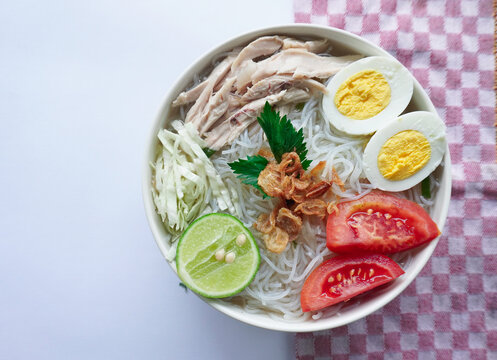 soto ayam bening or chicken soup is Indonesian food, made from rice, chicken broth, shredded chicken, boiled eggs, rice ,cabbage, vermicelli, tomatoes, celery and lime