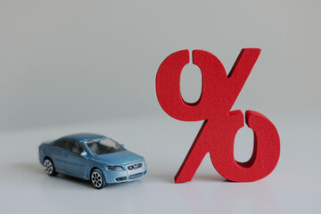 Toy car and a percentage sign on the table. The concept of insurance savings for families.