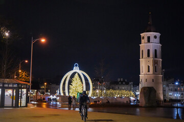 Obraz premium Christmas market at Cathedral Square in Vilnius with Bell Tower and decorated Christmas tree at night, Lithuania