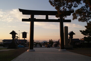 朝焼けに際立つ大鳥居と灯籠のシルエット