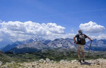 A hiker explores the landscape of the Dolomites in Italy, admiring their impressive peaks and valleys full of beauty.