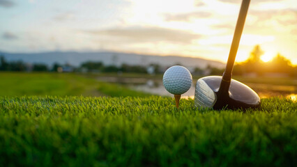 Golf clubs and balls on a green lawn in a beautiful golf course with morning sunshine.