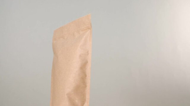 Zipper stand-up pouch spinning on light grey background, closeup. Space for text
