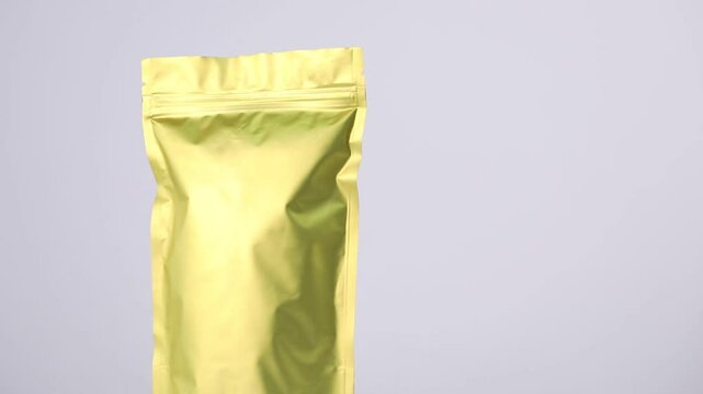Zipper stand-up pouch spinning on light grey background, closeup. Space for text
