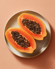 Juicy papaya halves delight with intact seeds on plate, vibrant and appetizing