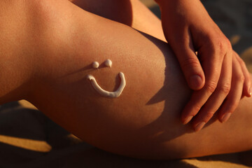 Sunscreen on woman's leg. Close-up drawing of smiling face with sunscreen on skin. Summer season, beach, tan. Woman sunbathing on beach. Cream protects skin from sunburn, safe tan, SPF protection