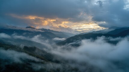 Majestic Mountain Landscape at Dawn with Clouds and Mist in the Valleys Under a Dramatic Sky