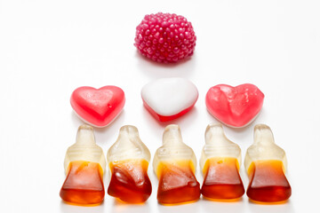 Fruit jelly beans in many colors in a glass bowl on a white background.