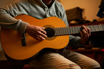 Obraz premium man playing acoustic guitar in his studio