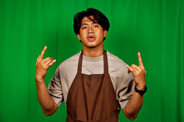 Young Man Wearing Apron Making Hand Gestures in Front of Green Screen