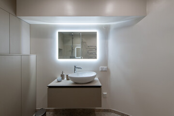 Modern Restroom Interior With Illuminated Vanity Mirror and Minimalist Decor
