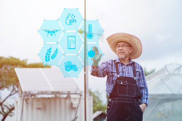 Man push tool on screen in smart farm with solar panels  and wind turbine on background.