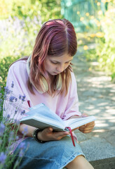 Girl enjoying reading a book outdoors