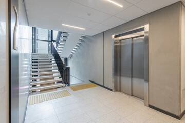 Modern Building Interior with Staircase and Elevator on the Second Floor © Mindaugas Dulinskas