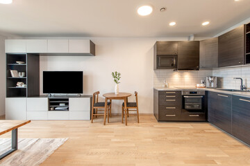 Modern Open Kitchen Featuring Wooden Flooring and Sleek Cabinets with Dining Area
