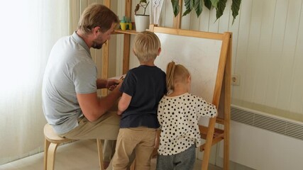 Father doing art with son and daughter. Daddy and his children coloring together. Brutal bearded dad and young kids drawing at home having fun at home. Happy family time. Real authentic lifestyle - Powered by Adobe