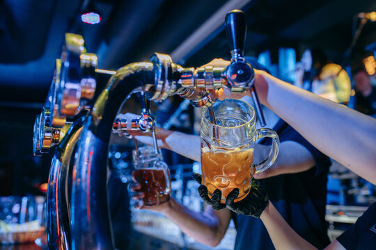 Bartender pouring beer at the bar. Close up hands