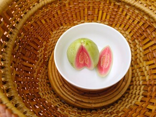 Red-fleshed guava halves are in a basket