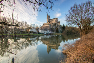 A winter landscape shot at sunrise. Plenty of nature and a large church on a rock. The former collegiate church of St. Lubentius Limburger, Dietkirchen, Hesse