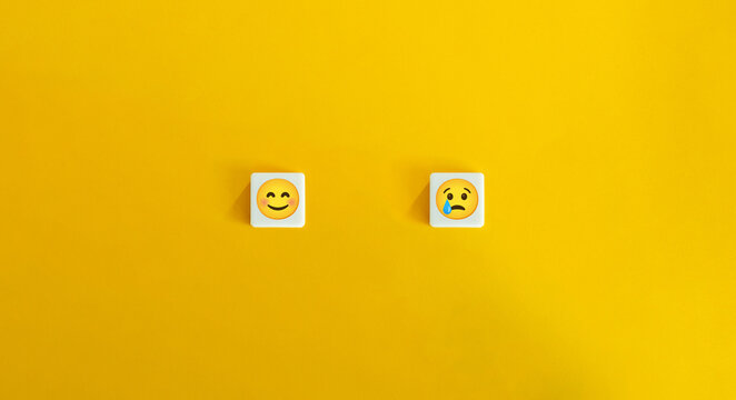 Happy and Sad Emoji Faces on Letter Tiles Over Yellow Minimalist Background - Powered by Adobe