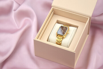 Closeup minimal fashion wristwatch for women on pink background.