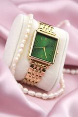 Closeup minimal fashion wristwatch for women on pink background.