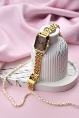 Closeup minimal fashion wristwatch for women on pink background.