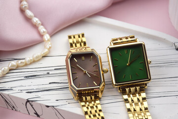 Closeup minimal fashion wristwatch for women on pink background.