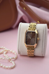 Closeup minimal fashion wristwatch for women on pink background.