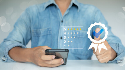 Customer giving five-star rating review using smartphone, showing satisfaction and trust approval symbol for business service quality.