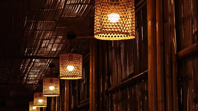 Hanging woven bamboo lamp with warm glowing lights.
