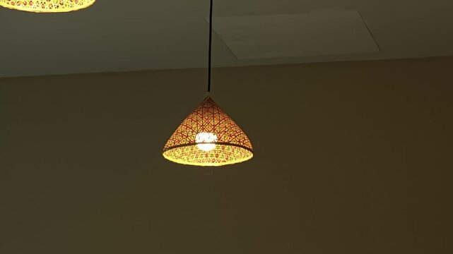 Hanging woven bamboo lamp with warm glowing lights.
