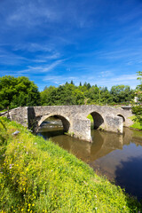 Historic Stone Bridge Spanning Tranquil River in Occitanie