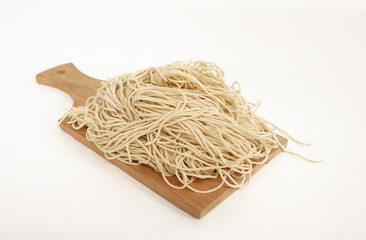 raw ramen noodle in wood cutting board isolated on white background. fresh egg ramen noodle isolated on white background. Japanese food ramen noodle isolated on white background. copy space