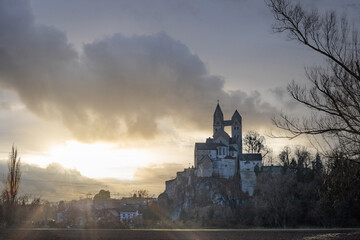 A winter landscape shot at sunrise. Plenty of nature and a large church on a rock. The former collegiate church of St. Lubentius Limburger, Dietkirchen, Hesse