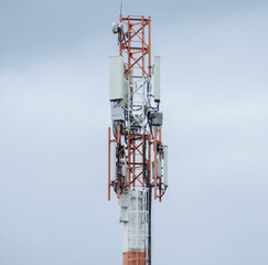 Communication tower stands against a cloudy sky in an urban area showcasing modern technology infrastructure