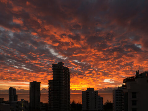 High-rise buildings silhouetted against a sunset sky