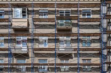 An old building in scaffolding during renovation and painting of the facade.