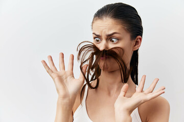 Funny portrait of a surprised woman with hair styled as a mustache, expressing playful emotions on...