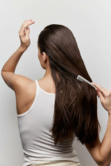 Hair care, grooming, brushing, beautiful hair, women s hairstyles A young woman with long, straight...